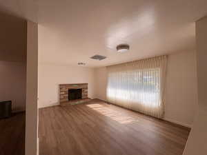Unfurnished living room with a fireplace and wood finished floors