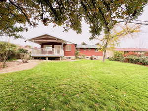 Rear view of property featuring a yard and brick siding