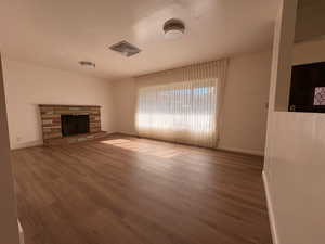 Unfurnished living room featuring wood finished floors and a fireplace
