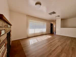 Unfurnished living room with a fireplace and wood finished floors