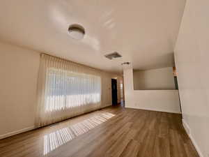 Unfurnished room with wood finished floors and baseboards