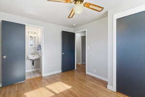 Unfurnished bedroom with light wood finished floors, ceiling fan, and connected bathroom