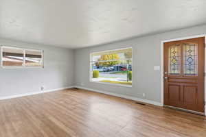 Foyer entrance featuring plenty of natural light, light wood-type flooring, and a textured ceiling