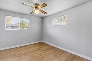 Spare room featuring a textured ceiling, light wood finished floors, and a ceiling fan