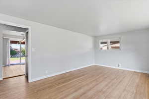 Unfurnished room with light wood-style floors and a chandelier