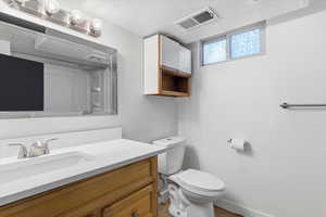 Half bath featuring a textured ceiling and vanity