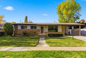 Ranch-style home featuring brick siding and an attached carport