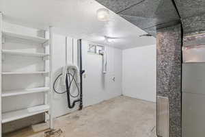 Below grade area with a textured ceiling and heating unit
