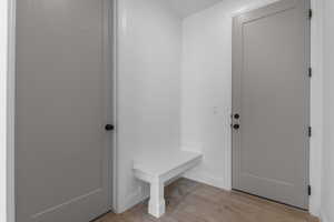Mudroom with light wood-style flooring and baseboards