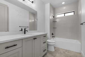 Bathroom featuring vanity,  shower combination, and recessed lighting