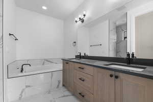 Full bathroom with light marble finish flooring, double vanity, a marble finish shower, a garden tub, and recessed lighting