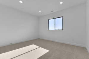 Carpeted empty room featuring recessed lighting and baseboards