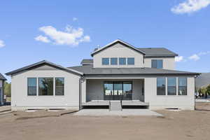 Rear view of house with a patio area and stucco siding