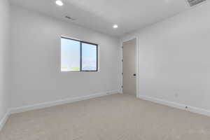 Carpeted empty room with baseboards and recessed lighting