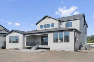 Rear view of property with a patio, stucco siding, and a shingled roof