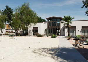 View of front of property featuring a patio, stucco siding, and a balcony