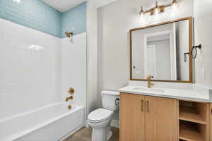 Full bathroom with  shower combination, vanity, and dark tile patterned flooring