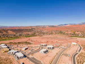 Aerial view of sparsely populated area featuring a mountainous background and nearby suburban area