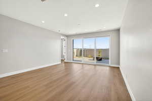 Empty room with light wood-style flooring and recessed lighting