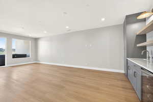 Unfurnished living room featuring beverage cooler, light wood-type flooring, and recessed lighting