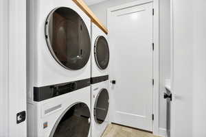 Laundry room with stacked washing machine and dryer