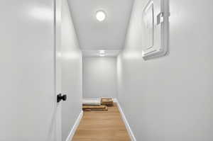 Hallway featuring light wood finished floors and electric panel