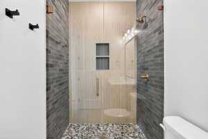 Bathroom with a shower stall and toilet