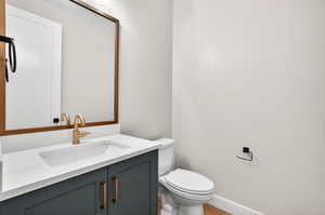 Half bathroom with vanity and toilet