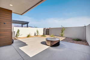 Fenced backyard with a patio, a pergola, and a fire pit