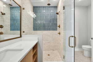 Full bath featuring a shower stall, vanity, and light tile patterned flooring