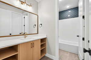 Bathroom featuring vanity, light tile patterned floors, and tub / shower combination