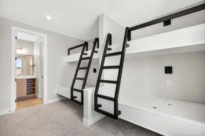 Bathroom with light colored carpet, recessed lighting, and vanity