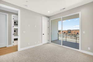 Unfurnished bedroom with carpet, access to exterior, and recessed lighting