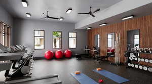 Exercise room featuring a ceiling fan and wooden walls