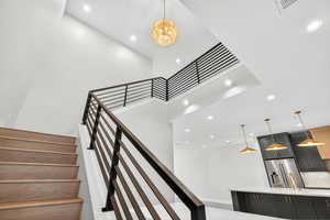 Stairs with recessed lighting and a towering ceiling