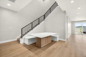 Staircase with recessed lighting and wood finished floors