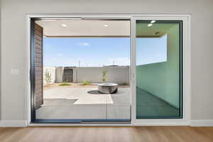Doorway to outside with wood finished floors and healthy amount of natural light