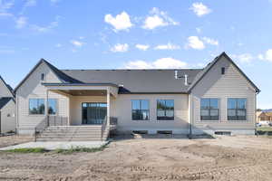 Rear view of house featuring a patio area and roof with shingles