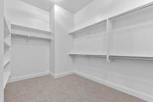 Walk in closet featuring light colored carpet