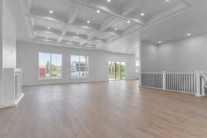 Unfurnished living room featuring coffered ceiling, beamed ceiling, recessed lighting, and light wood finished floors