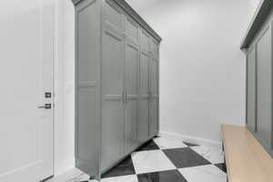 Mudroom with baseboards and light marble finish floors