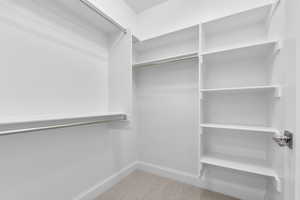 Walk in closet with light carpet