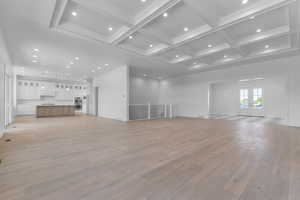 Unfurnished living room with french doors, recessed lighting, coffered ceiling, beamed ceiling, and light wood-type flooring