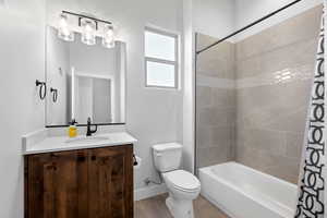 Full bathroom featuring shower / bath combination with curtain, vanity, and light tile patterned flooring