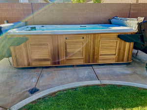 View of pool with a hot tub and a patio area