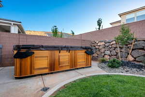 Fenced backyard with a hot tub and a patio
