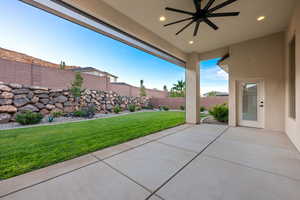 Fenced backyard with a patio area and ceiling fan