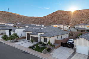 View of front of property featuring a residential view, stucco siding, driveway, and a mountain view
