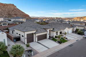 View of front of home featuring a residential view, concrete driveway, a garage, stucco siding, and a mountain view