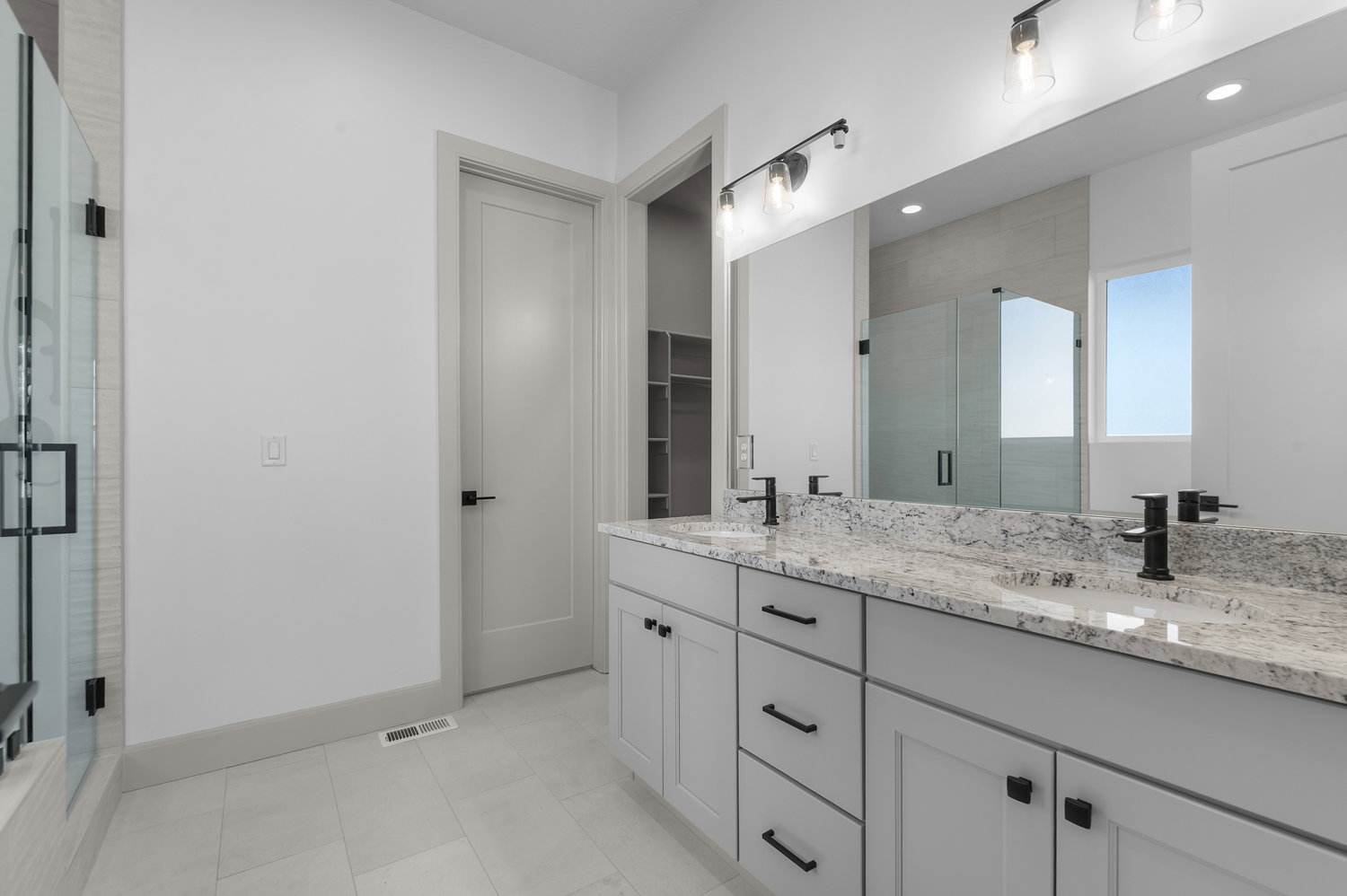 Full bathroom featuring double vanity, a stall shower, a walk in closet, light tile patterned flooring, and recessed lighting